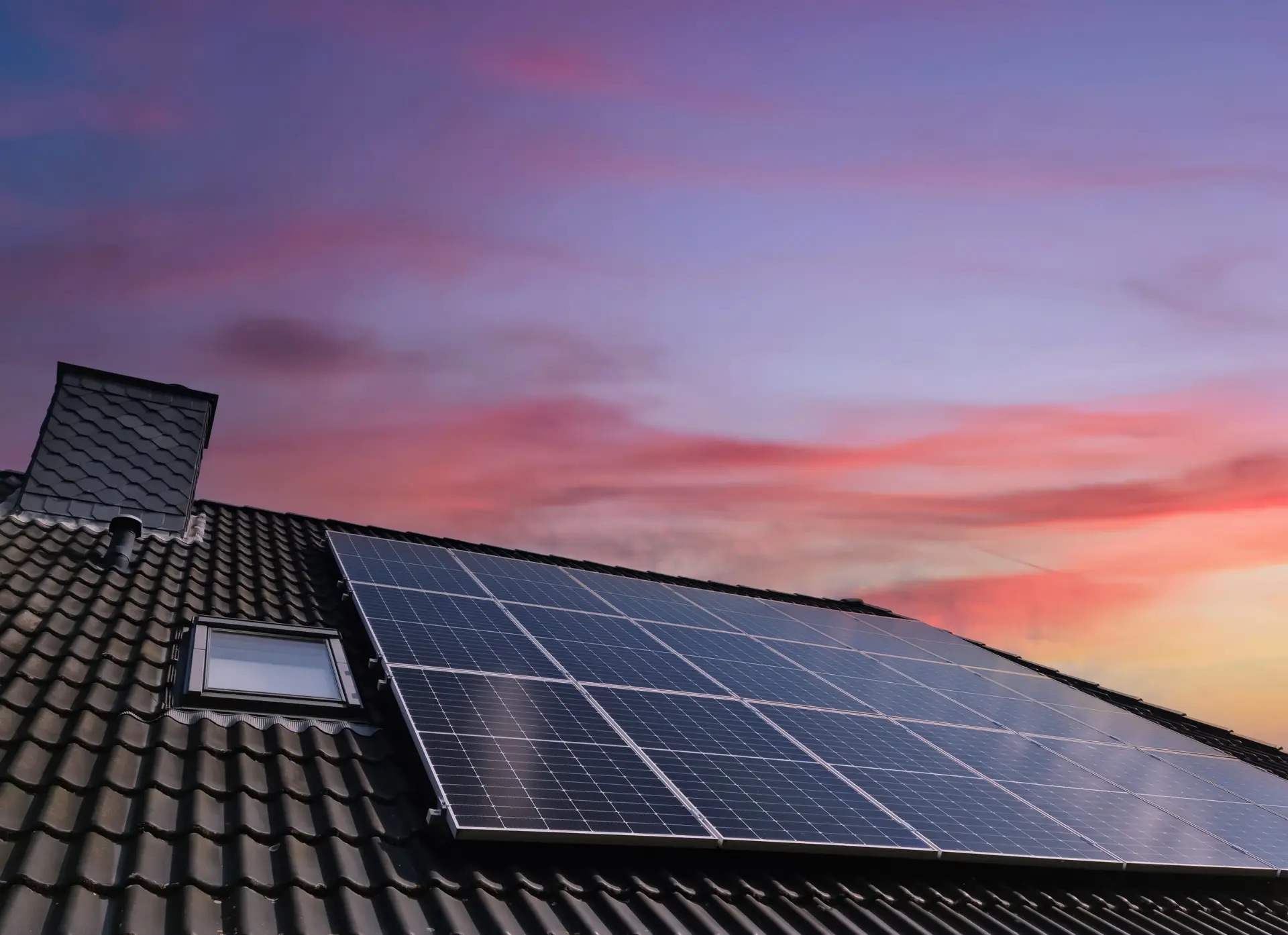 Dak met zonnepanelen bij zonsondergang